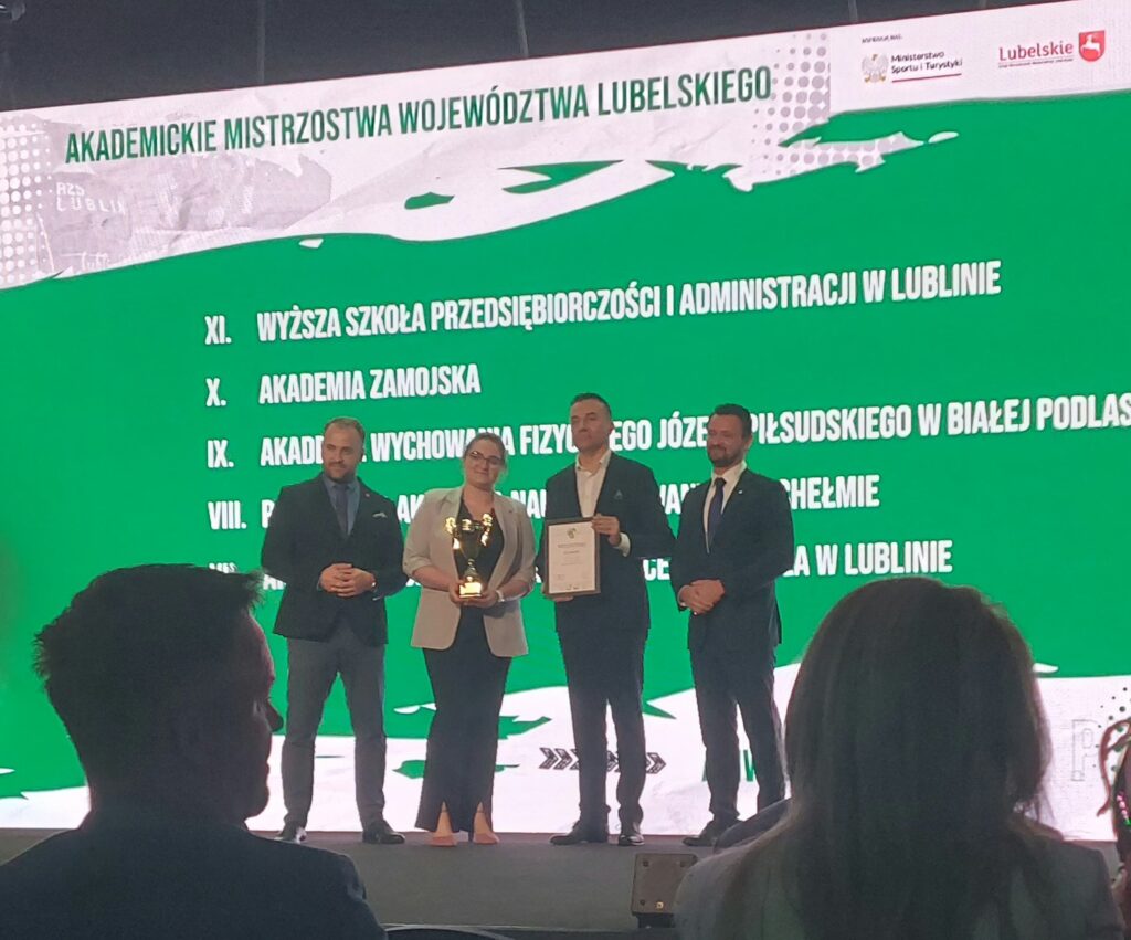 Władze uczelni na scenie odbierający puchar.